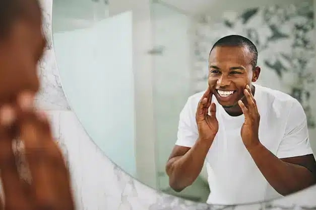 Man smiling seeing into the mirror after botox treatment at Altamonte Springs